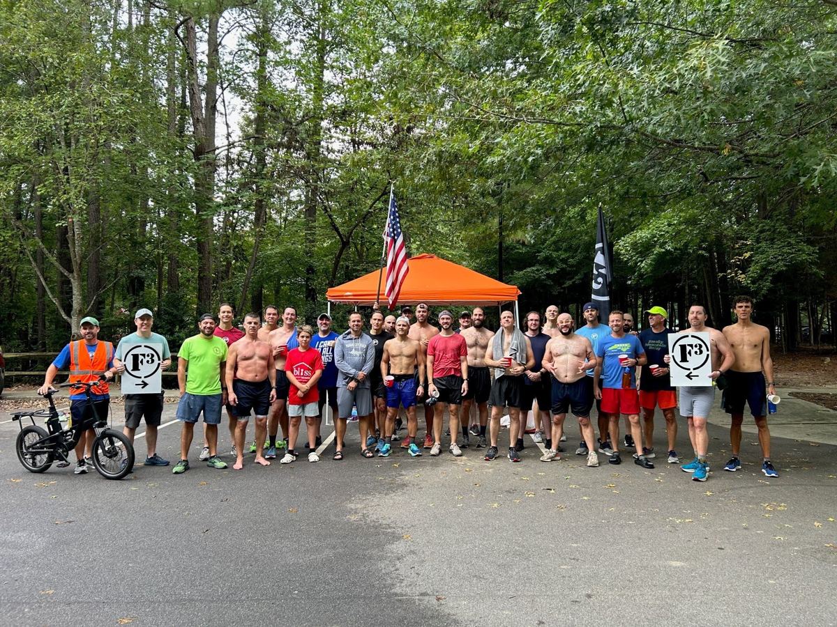 A large group of F3 men with F3 signs after a morning run